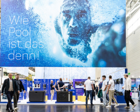 Large Aquanale 2025 advertising billboard featuring a swimmer and the slogan “Wie Pool ist das denn!” in the middle of the exhibition stands.