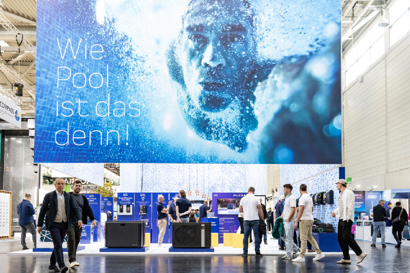 Large Aquanale 2025 advertising billboard featuring a swimmer and the slogan “Wie Pool ist das denn!” in the middle of the exhibition stands.