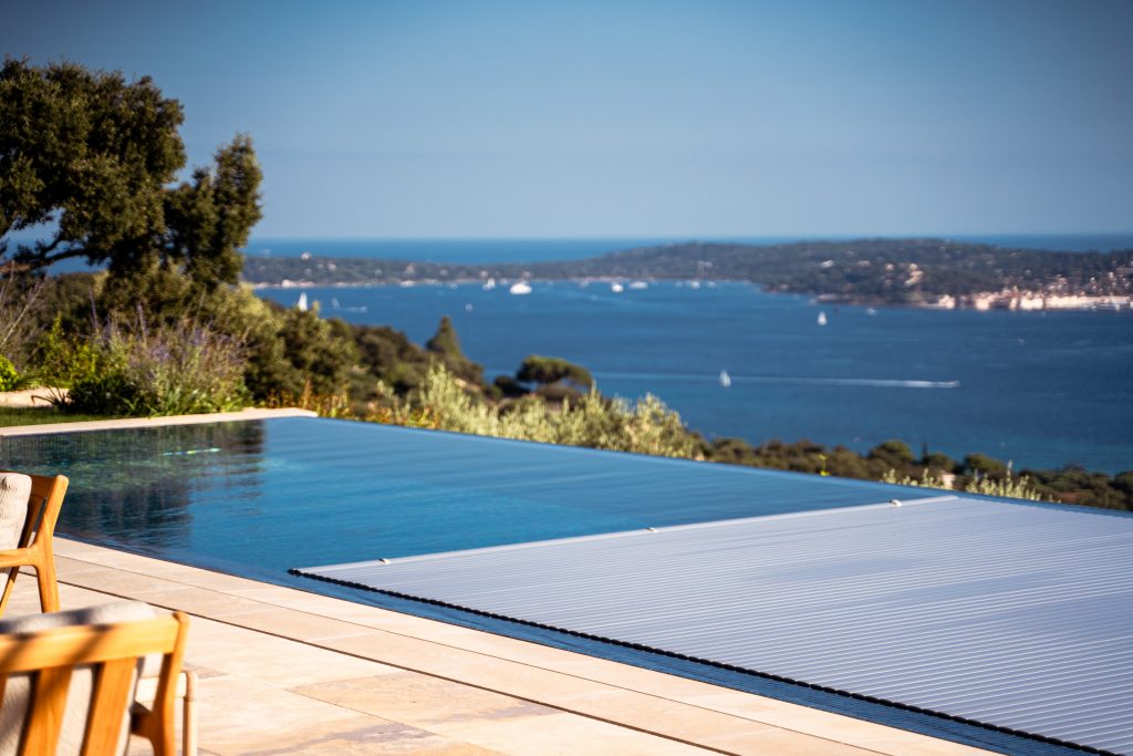 Automatischer Lamellen-Poolabdeckung für einen Infinity-Pool mit Blick auf das Meer