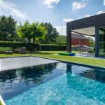 Automatischer Poolabdeckung in den Garten eines modernen Hauses integriert.
