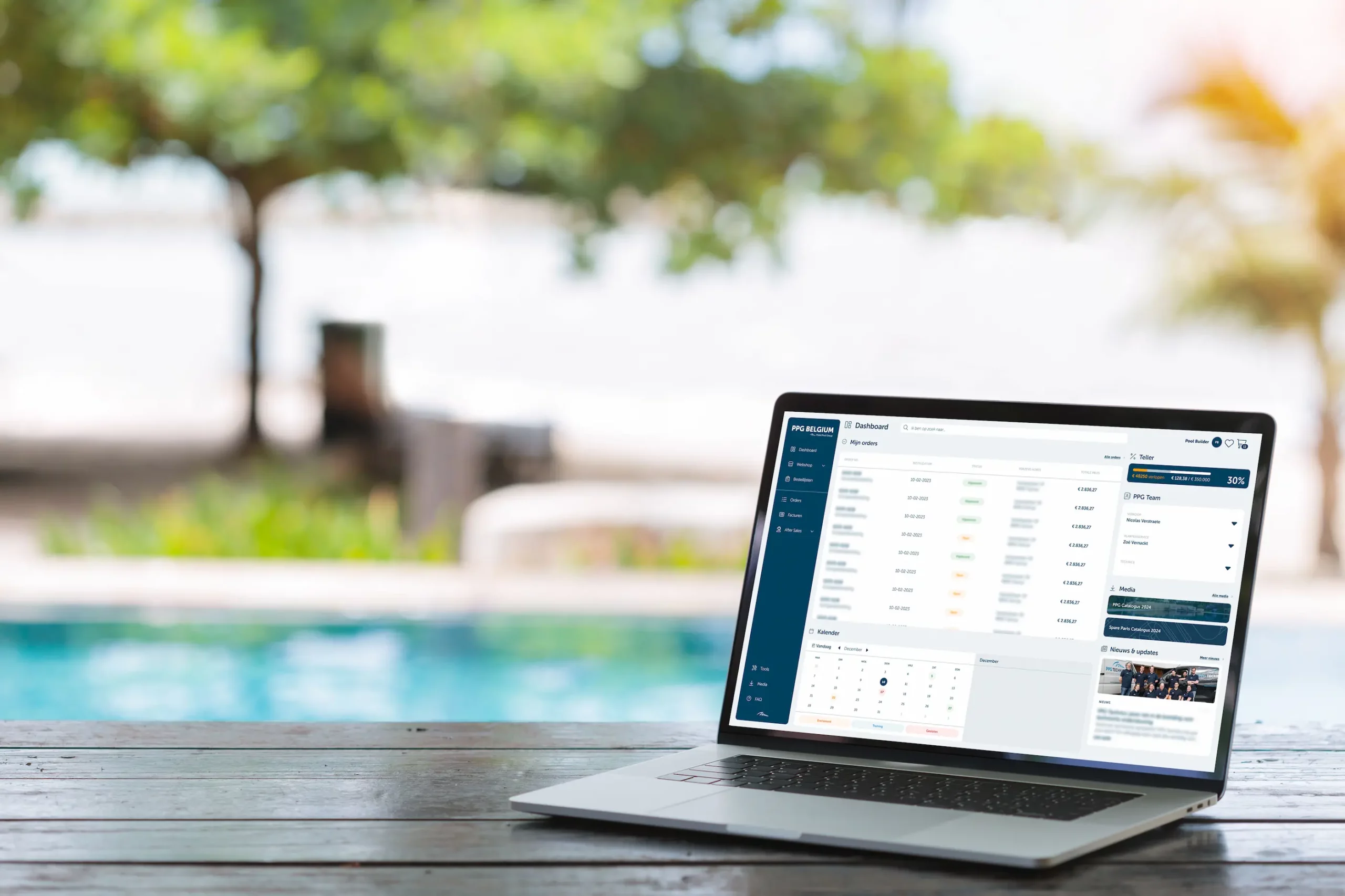 Ein Laptop auf einem Holztisch neben einem Swimmingpool mit dem MY PPG-Dashboard geöffnet auf dem Bildschirm.