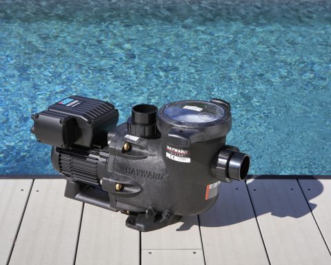 Hayward TriStar VSTD variable speed pool pump installed on a deck next to a swimming pool.