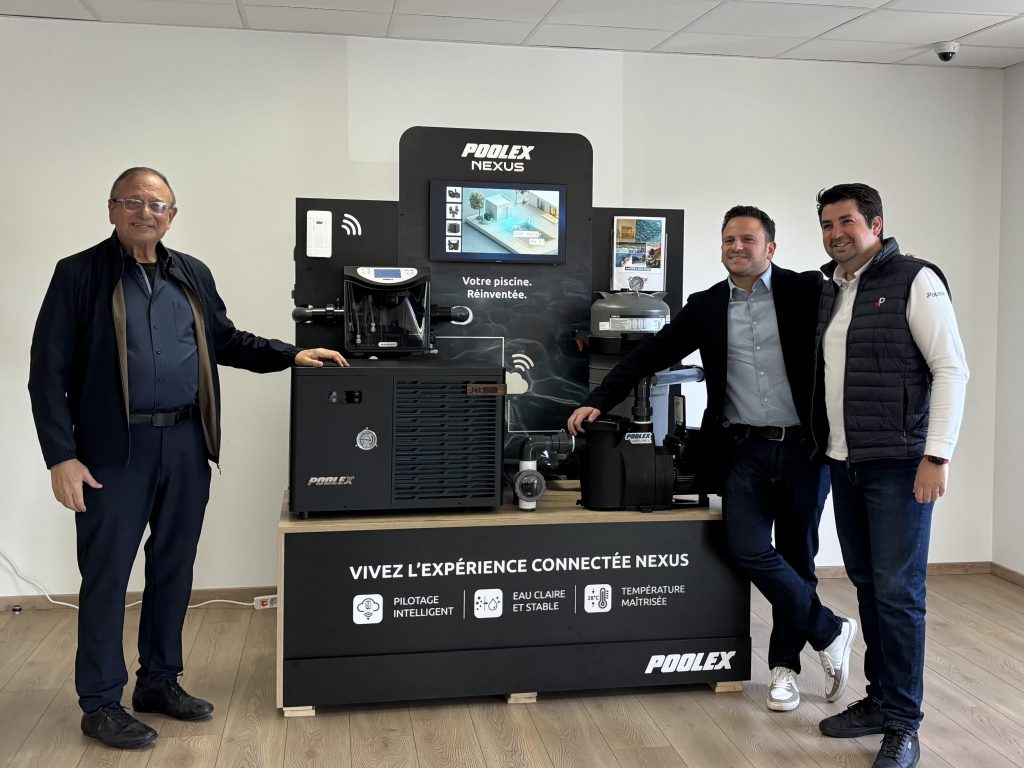 Trois dirigeants de Poolstar posant devant le stand de présentation du système connecté Poolex Nexus.