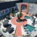 Vue aérienne du showroom extérieur de Poolstar avec piscine, saunas et paddles colorés.