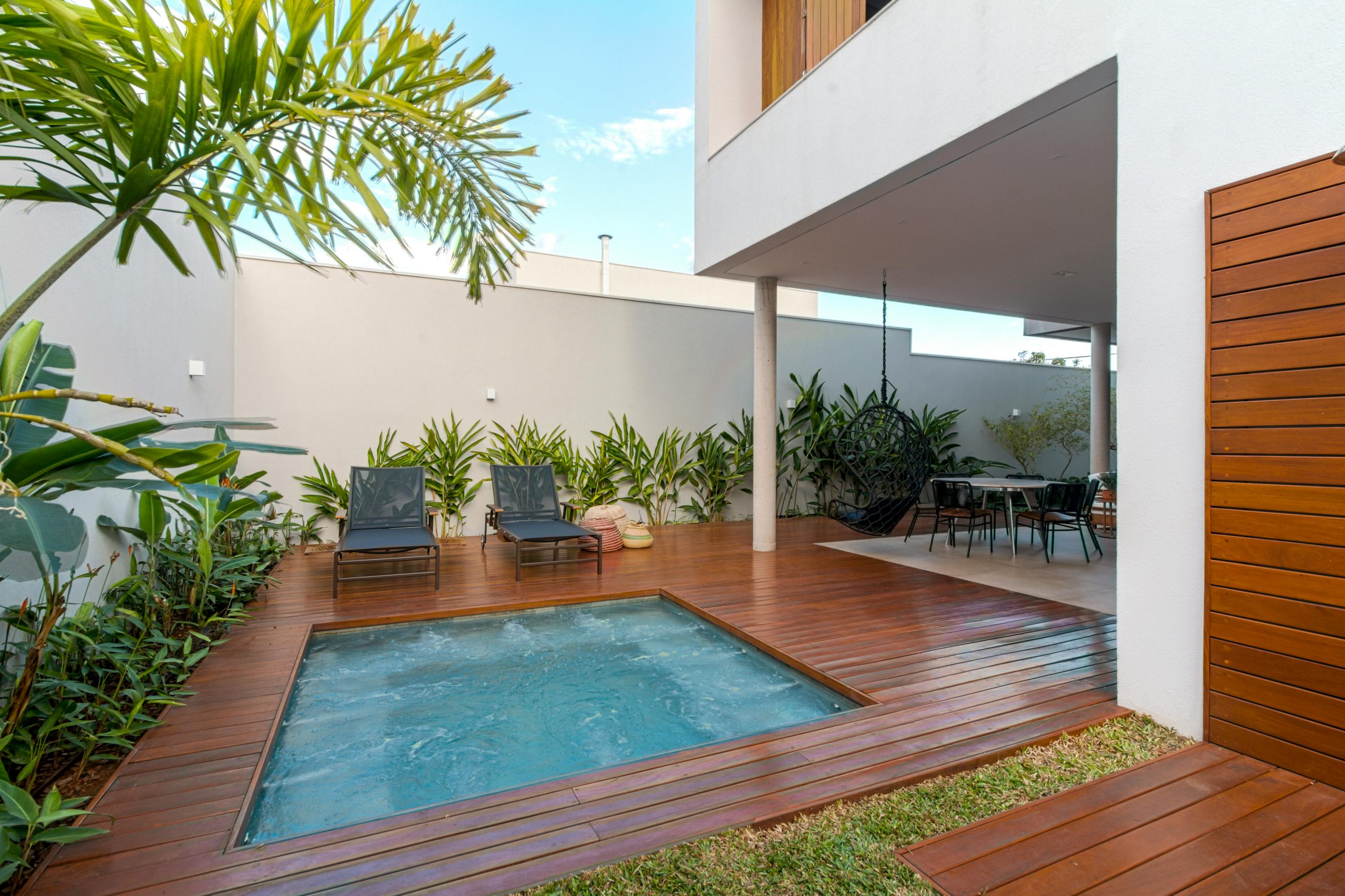 Modern smart mini pool integrated into a luxury wooden deck patio of a contemporary townhouse