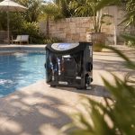 A Poolex Aqualyser automated water treatment and dosing unit placed horizontally on the stone edge of a sunny residential swimming pool.