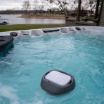Purezone floating spa water monitor floating in outdoor hot tub water.