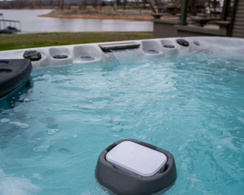 Purezone floating spa water monitor floating in outdoor hot tub water.