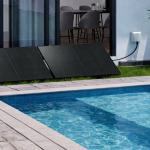 Poolex Plug and Play solar kit with two photovoltaic panels installed on the lawn next to a swimming pool