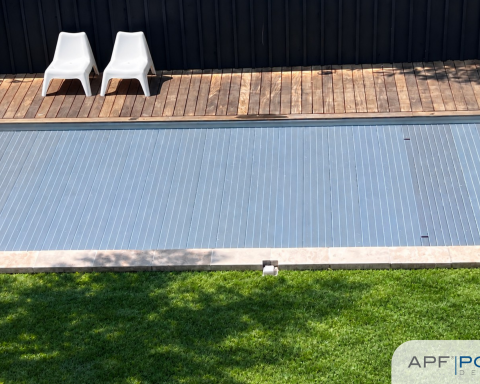Top view of a swimming pool covered with the APF Pool Design DeckLine X320 slatted cover