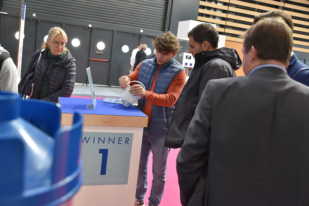 Exhibitor demonstrating a new pool component to visitors at an award-winning innovation stand