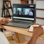 Professional attending an e-learning session on a laptop for pool trade remote training.