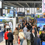 Busy exhibition hall featuring innovative pool equipment stands and attendees walking around